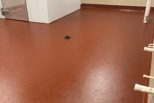 Best epoxy commercial kitchen floor in solid terra cotta color showing drains and coving in alternate view. Installed by Young Flooring in Winston-Salem.